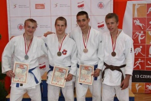 Szymon Woźniak (drugi z lewej) ze złotym medalem.