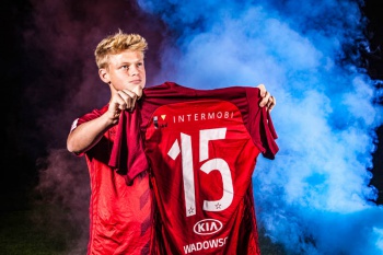 Patryk Pischinger prezentuje koszulkę z nazwą nowego sponsora, Intermobi.